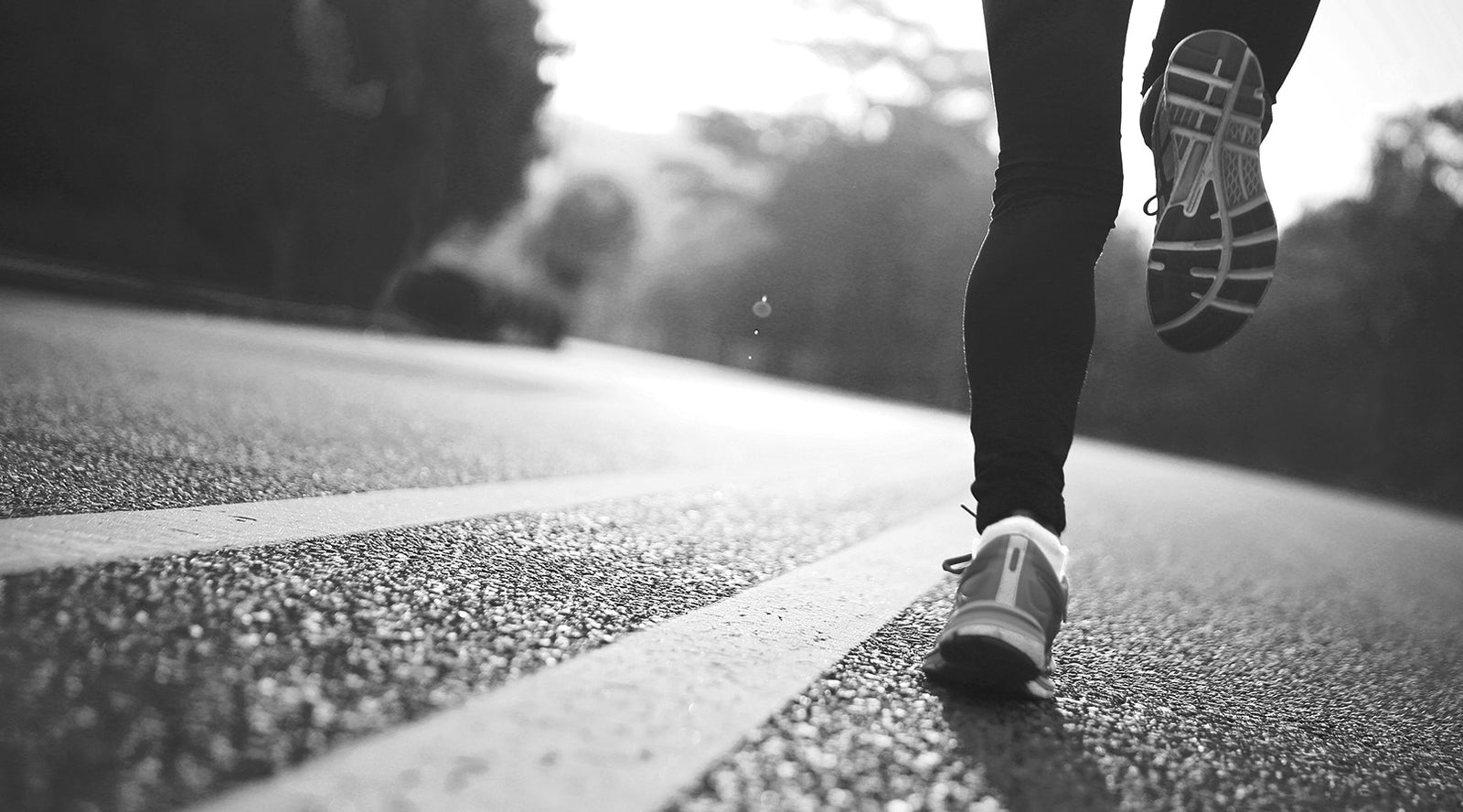 Woman Running on Paved Road